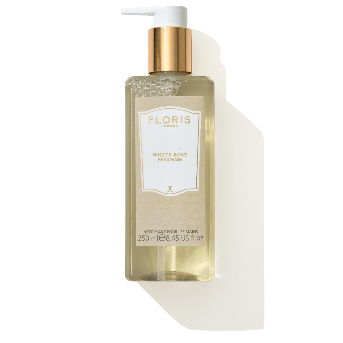 A clear bottle of Floris London White Rose - Luxury Hand Wash with a gold pump, containing 250 mL of mild hand wash enriched with coconut and olive-derived ingredients.