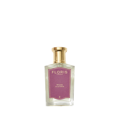 A clear glass bottle of Floris London Wilde Eau de Parfum with a gold cap and purple label, inspired by Oscar Wilde’s creative spirit.