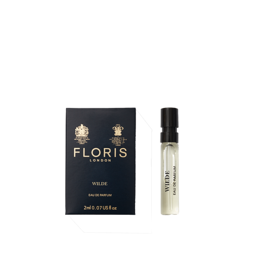 A Floris London Wilde - Eau de Parfum sample vial sits beside its navy blue box, embodying individuality and creative expression.